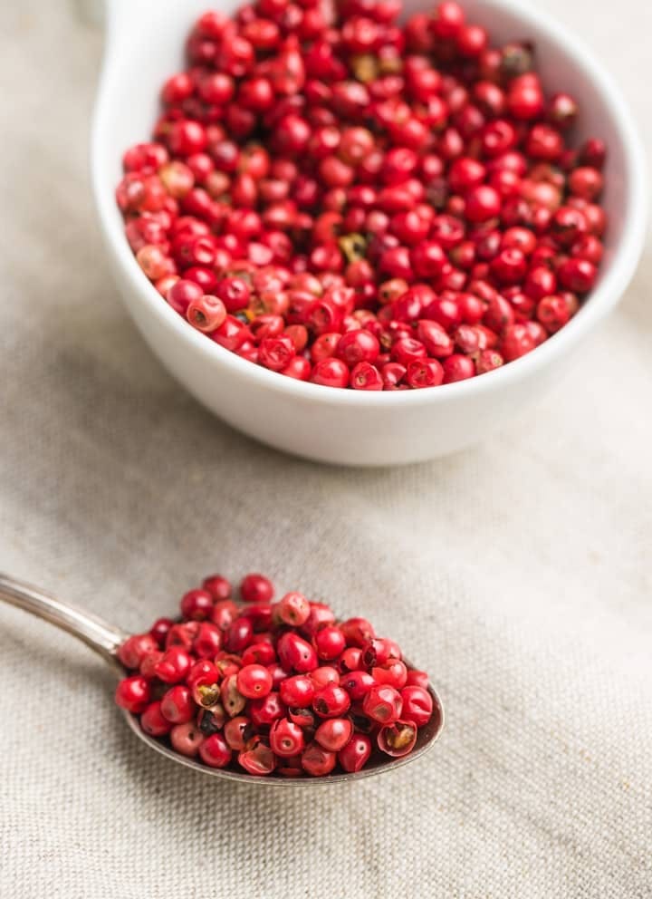 Rosa Beeren in einer Schüssel und auf einem Löffel